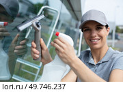 happy woman cleaning window with rag and spray. Стоковое фото, агентство Ingram Publishing / Фотобанк Лори