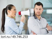 angry female boss shouting through megaphone at oblivious male employee. Стоковое фото, агентство Ingram Publishing / Фотобанк Лори