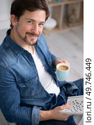 happy man drinking coffee and doing crosswords. Стоковое фото, агентство Ingram Publishing / Фотобанк Лори