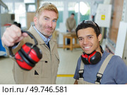 a male worker giving earmuff. Стоковое фото, агентство Ingram Publishing / Фотобанк Лори