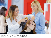 hair stylist makes a curls for a girl. Стоковое фото, агентство Ingram Publishing / Фотобанк Лори