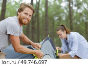 travelers assembling tent to spend night by the lake. Стоковое фото, агентство Ingram Publishing / Фотобанк Лори