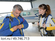 a parachutist is securing equipment. Стоковое фото, агентство Ingram Publishing / Фотобанк Лори