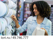smilling woman choosing ribbon or elastic band at store. Стоковое фото, агентство Ingram Publishing / Фотобанк Лори