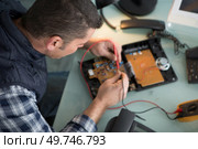 technician repairing a telephone handset. Стоковое фото, агентство Ingram Publishing / Фотобанк Лори