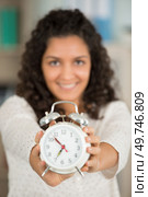 woman showing the time on an alarm clock. Стоковое фото, агентство Ingram Publishing / Фотобанк Лори