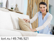 woman tidying up a sofa. Стоковое фото, агентство Ingram Publishing / Фотобанк Лори