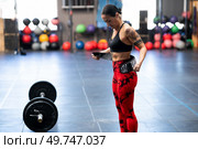 Mature sportive strong woman tying a belt to prevent injures while weightlifting. Woman tying a belt to prevent injures while weightlifting. Стоковое фото, агентство Ingram Publishing / Фотобанк Лори
