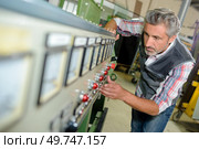 technician fixing a complex machine. Стоковое фото, агентство Ingram Publishing / Фотобанк Лори