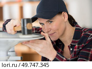 female contractor repairing furniture. Стоковое фото, агентство Ingram Publishing / Фотобанк Лори