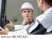 apprentice learning to measure windows. Стоковое фото, агентство Ingram Publishing / Фотобанк Лори