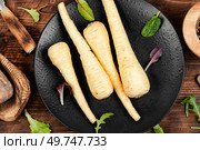Raw and uncooked parsnips roots on the kitchen table. Fresh vegetable. Top view.. Close up parsnip. Стоковое фото, агентство Ingram Publishing / Фотобанк Лори