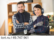 tradeswoman learning to use angle grinder to cut metal. Стоковое фото, агентство Ingram Publishing / Фотобанк Лори
