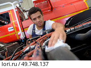 man cleaning the car radiator with his hand. Стоковое фото, агентство Ingram Publishing / Фотобанк Лори
