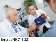 intern writing the patients blood pressure. Стоковое фото, агентство Ingram Publishing / Фотобанк Лори
