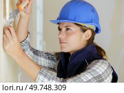professional female worker stripping wallpaper. Стоковое фото, агентство Ingram Publishing / Фотобанк Лори