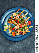 Barbecue seafood kebabs, shrimps prawns, mussels and grilled squid on skewers. Top view.. Tasty seafood kebabs, shellfish. Стоковое фото, агентство Ingram Publishing / Фотобанк Лори