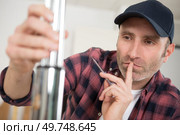 man contemplating how to assemble metal tubes. Стоковое фото, агентство Ingram Publishing / Фотобанк Лори