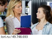 teacher holding file and questioning adolescent student. Стоковое фото, агентство Ingram Publishing / Фотобанк Лори