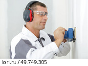 male builder using sander on plasterboard wall. Стоковое фото, агентство Ingram Publishing / Фотобанк Лори