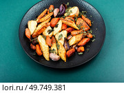 Winter garnish of baked sliced parsnip root, carrots and garlic.. Roasted parsnip root and carrots. Стоковое фото, агентство Ingram Publishing / Фотобанк Лори