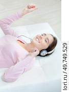 Lady listening to headphones, layed down dancing. Стоковое фото, агентство Ingram Publishing / Фотобанк Лори