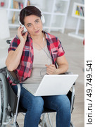 handicapped woman listens to music with her laptop. Стоковое фото, агентство Ingram Publishing / Фотобанк Лори