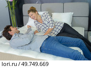 Couple layed on bed in showroom. Стоковое фото, агентство Ingram Publishing / Фотобанк Лори