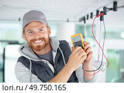 electrician using a multimeter to test spotlight connections. Стоковое фото, агентство Ingram Publishing / Фотобанк Лори