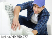 young man repairing air conditioner. Стоковое фото, агентство Ingram Publishing / Фотобанк Лори