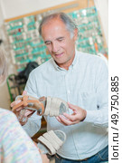 Cobbler discussing sandals with customer. Стоковое фото, агентство Ingram Publishing / Фотобанк Лори