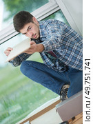 young handsome handyman installing new laminated wooden floor. Стоковое фото, агентство Ingram Publishing / Фотобанк Лори