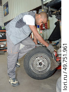 portrait of man worker fixing a tire. Стоковое фото, агентство Ingram Publishing / Фотобанк Лори