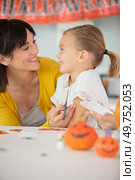 woman painting face of her daughter for the halloween celebration. Стоковое фото, агентство Ingram Publishing / Фотобанк Лори