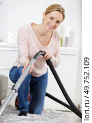 happy young woman hoovering carpet at home. Стоковое фото, агентство Ingram Publishing / Фотобанк Лори