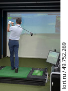 young man playing virtual golf game. Стоковое фото, агентство Ingram Publishing / Фотобанк Лори