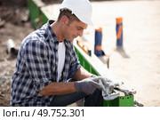 construction worker laying foundations at building site. Стоковое фото, агентство Ingram Publishing / Фотобанк Лори