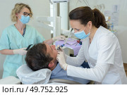 dentists with a patient during a dental intervention. Стоковое фото, агентство Ingram Publishing / Фотобанк Лори