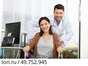 male doctor pushes female patient in wheelchair. Стоковое фото, агентство Ingram Publishing / Фотобанк Лори
