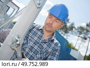 Workman tightening bolt on metal structure. Стоковое фото, агентство Ingram Publishing / Фотобанк Лори