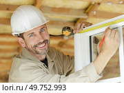 man measuring window prior to installation of roller shutter outdoors. Стоковое фото, агентство Ingram Publishing / Фотобанк Лори