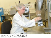 Factory worker filling sachet from hopper. Стоковое фото, агентство Ingram Publishing / Фотобанк Лори