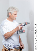 Builder drilling hole in wall. Стоковое фото, агентство Ingram Publishing / Фотобанк Лори