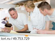 industrial painting apprentice studying the brush. Стоковое фото, агентство Ingram Publishing / Фотобанк Лори