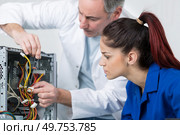 happy woman fixing computer at desk at work. Стоковое фото, агентство Ingram Publishing / Фотобанк Лори