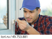 a young male worker fixing a window frame. Стоковое фото, агентство Ingram Publishing / Фотобанк Лори