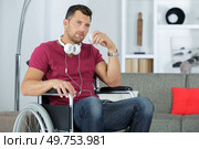 Man in wheelchair with headphones around his neck. Стоковое фото, агентство Ingram Publishing / Фотобанк Лори