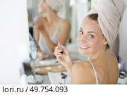 happy beautiful woman applies lip gloss. Стоковое фото, агентство Ingram Publishing / Фотобанк Лори