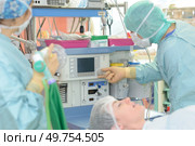 surgeons working with monitoring of patient in surgical operating room. Стоковое фото, агентство Ingram Publishing / Фотобанк Лори