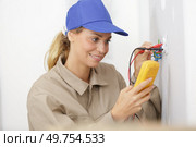 female electrician testing socket using a multimeter. Стоковое фото, агентство Ingram Publishing / Фотобанк Лори